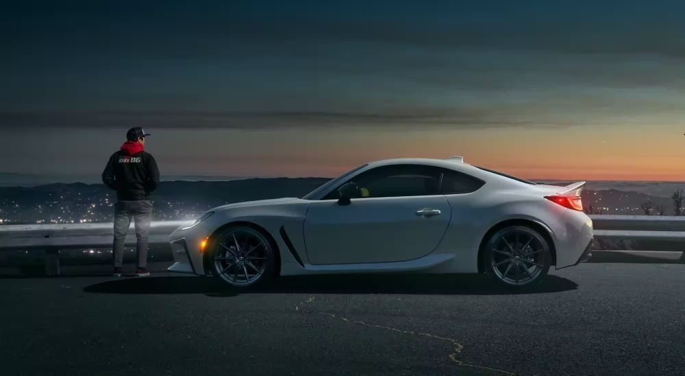 A white 2024 Toyota GR86 is shown from the side on an overlook.