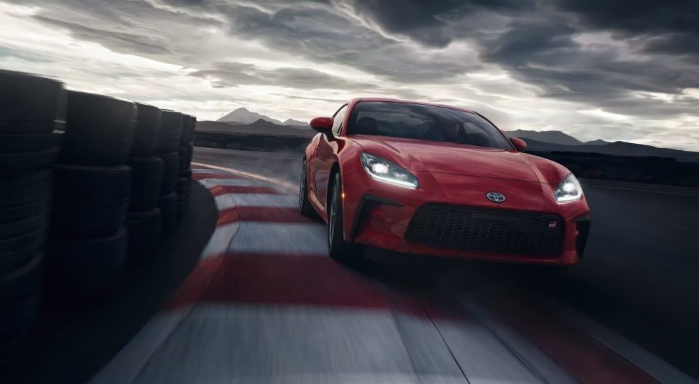 A red 2024 Toyota GR86 driving on a track.