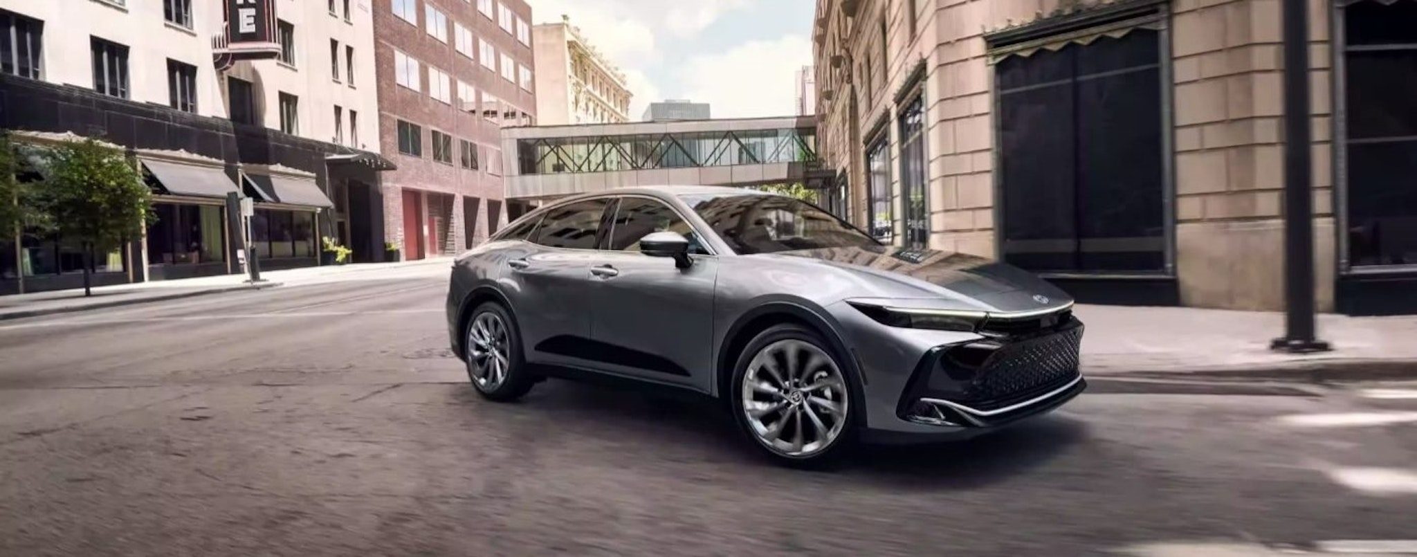 A silver 2023 Toyota Crown Limited is driving on a city street.