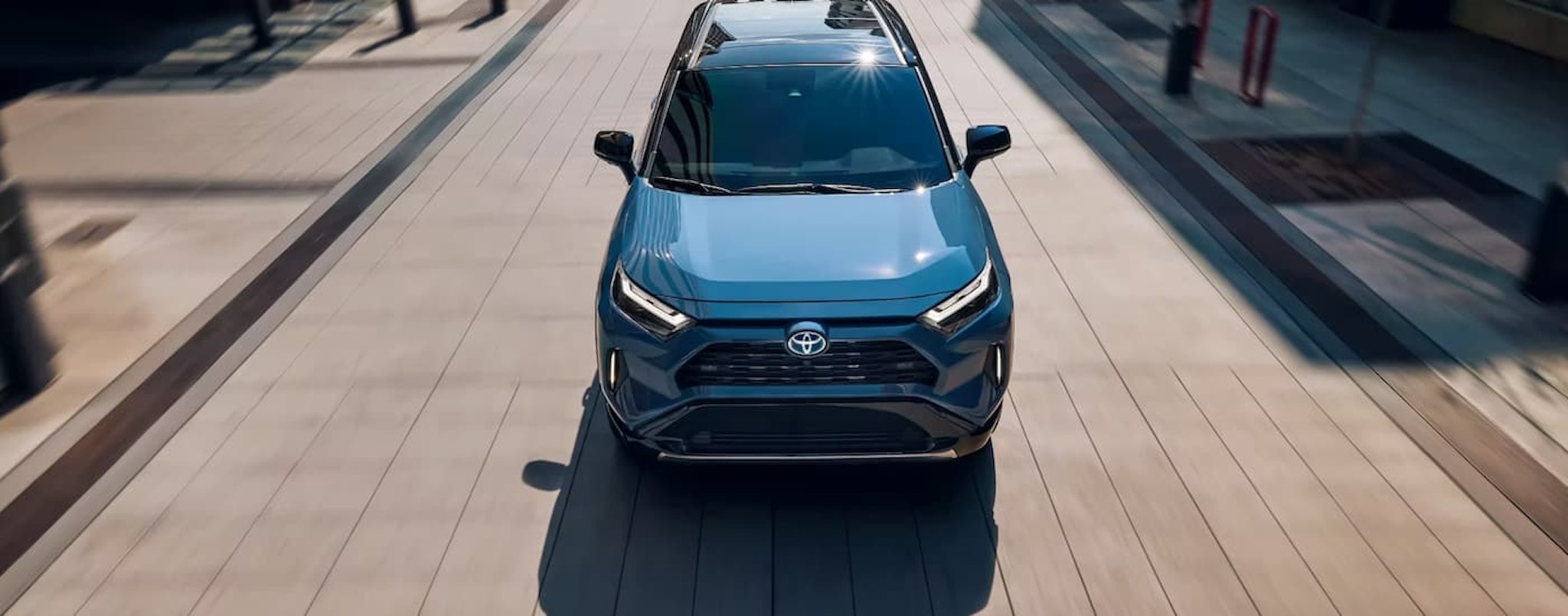 A blue 2022 Toyota RAV4 is shown speeding on a city street.