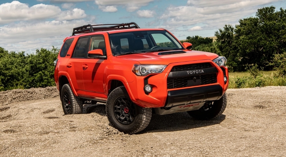 An orange 2024 Toyota 4Runner TRD Pro is shown off-road after leaving a Toyota dealership.