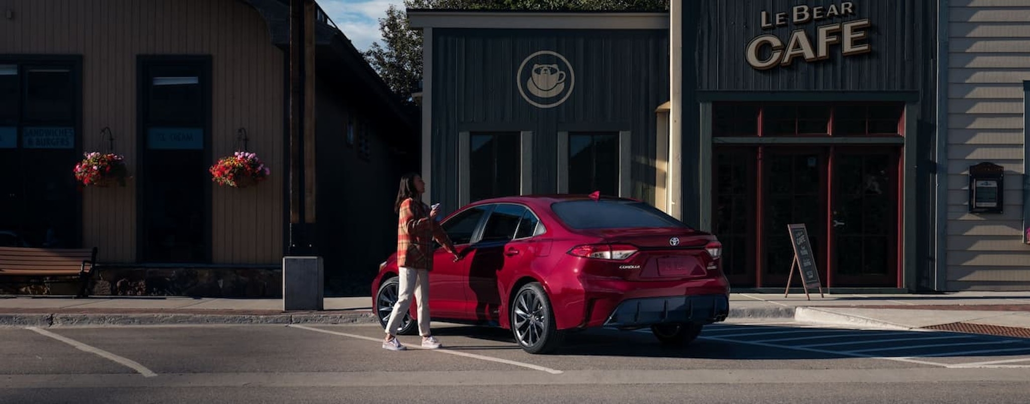 A red 2024 Toyota Corolla Hybrid SE parked outside of a coffee shop.