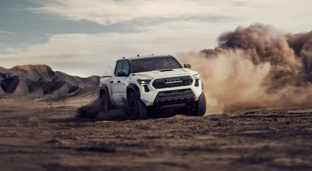 A white 2024 Toyota Tacoma TRD is shown from the front at an angle.