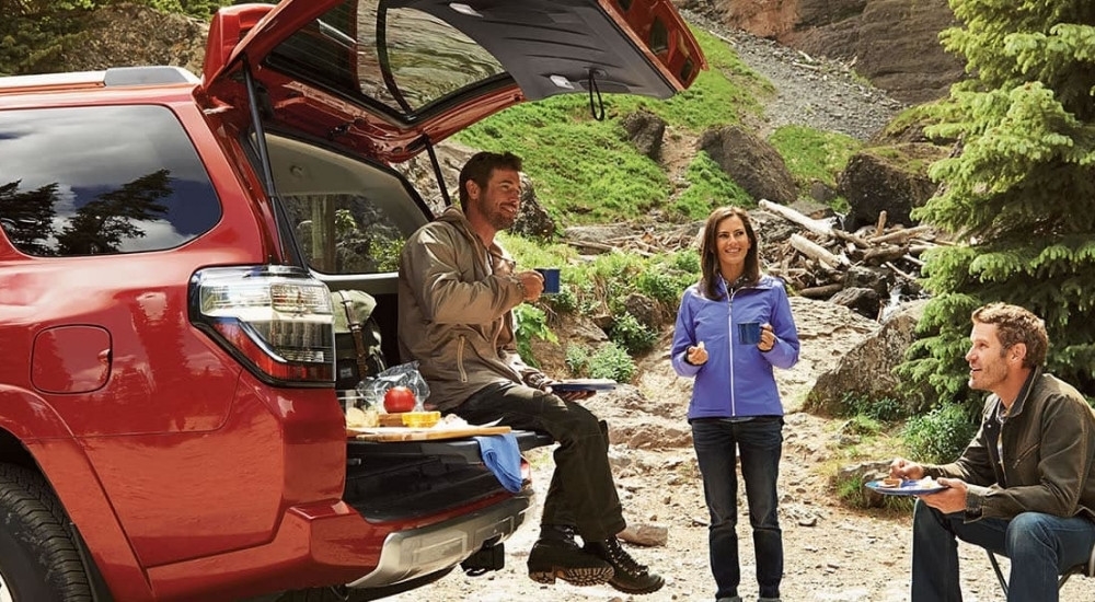 People are shown near a red 2014 Toyota 4Runner.