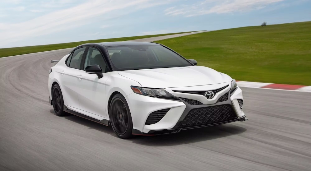 A white 2023 Toyota Camry TRD driving on a track after leaving a dealer that has a used Toyota for sale.