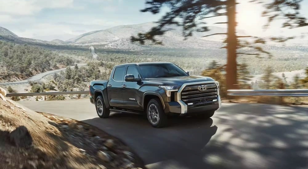 A gray 2023 Toyota Tundra is shown driving uphill after viewing used SUVs for sale.