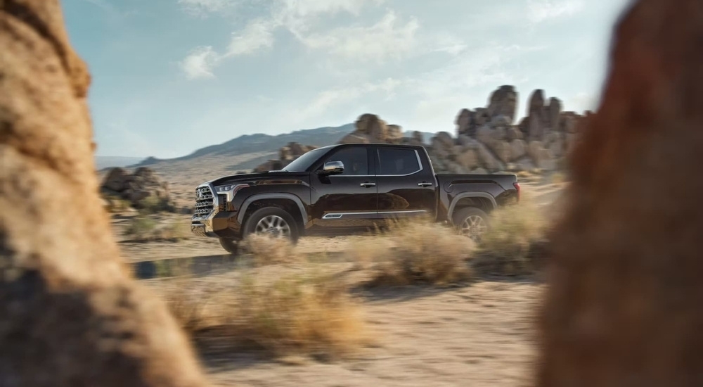 A grey 2023 Toyota Tundra is shown from the side while off-road