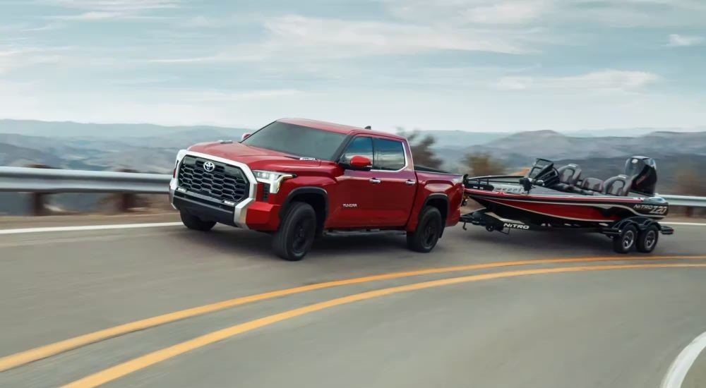 A red 2024 Toyota Tundra towing a bass boat.