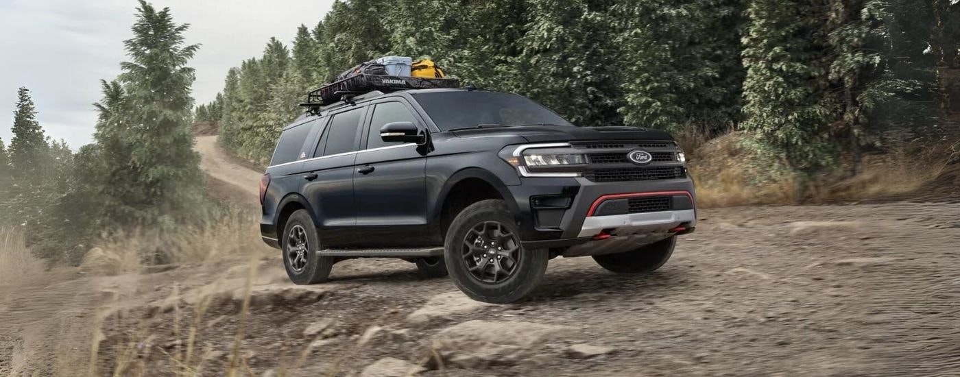 A black 2022 Ford Expedition Timberline is shown on a tree-lined trail.