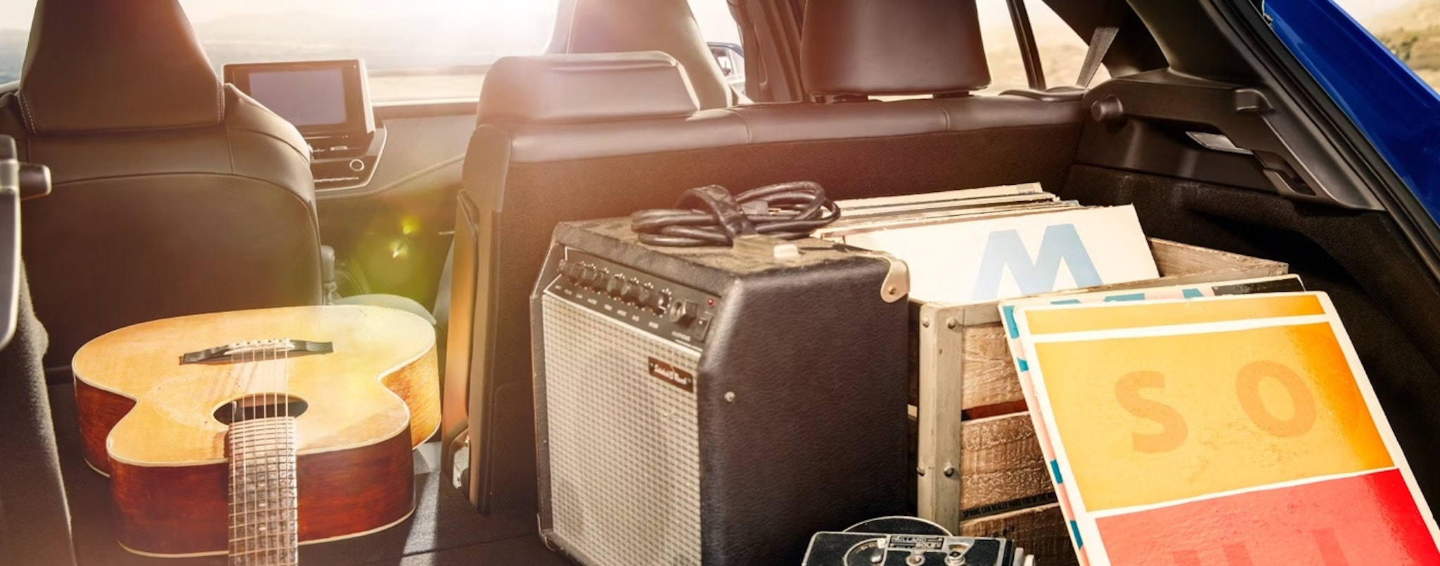 The rear cargo area of a 2025 Toyota Corolla Hatchback XSE loaded with musical instruments and gear.