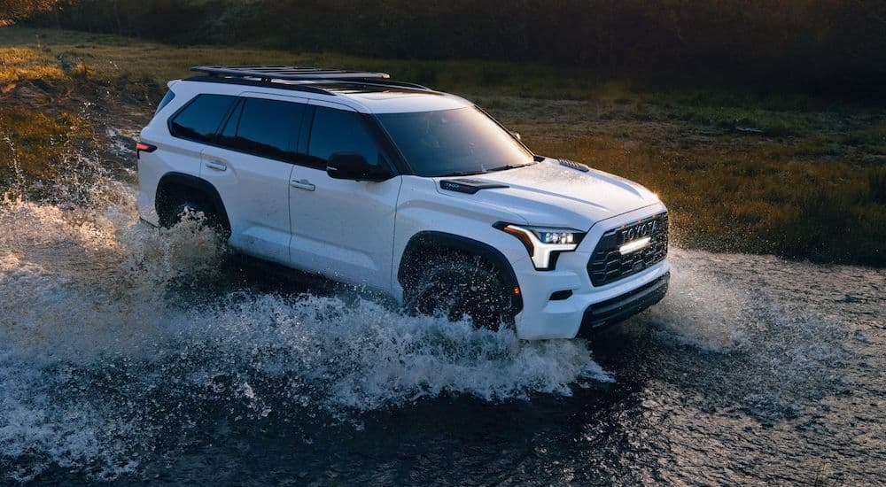 A white 2024 Toyota Sequoia TRD driving through water.
