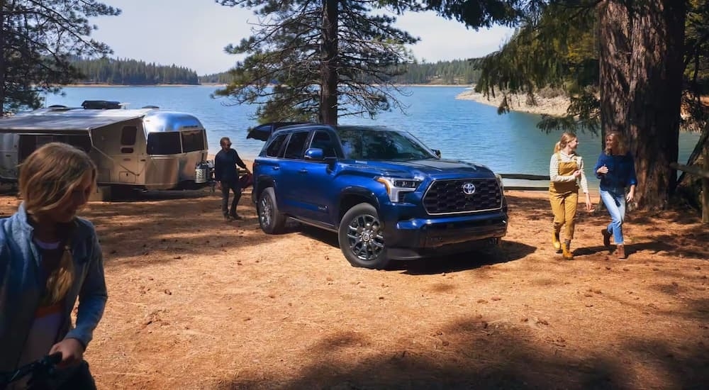 A blue 2024 Toyota Sequoia parked on a campsite.