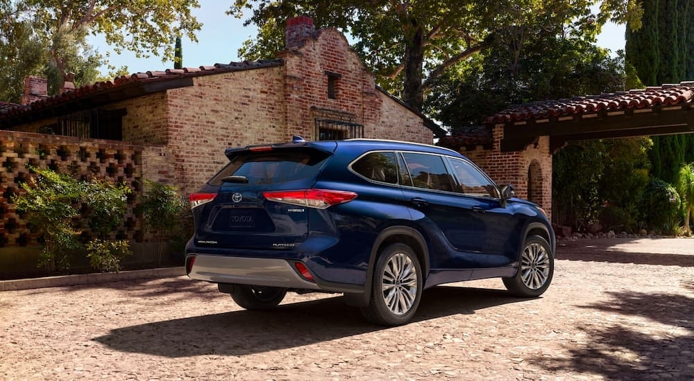 A blue 2023 Toyota Highlander is shown from the rear at an angle after leaving a Toyota dealer near Claremont.