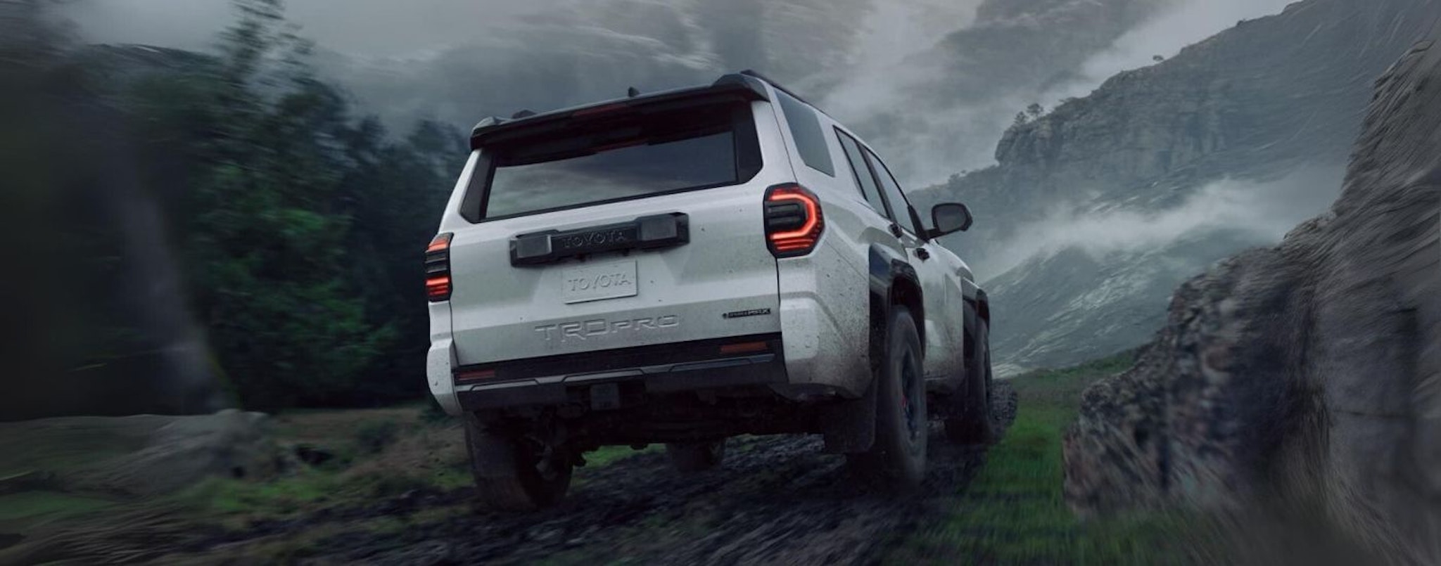 A white 2025 Toyota 4Runner TRD Pro is shown from the rear off-road.