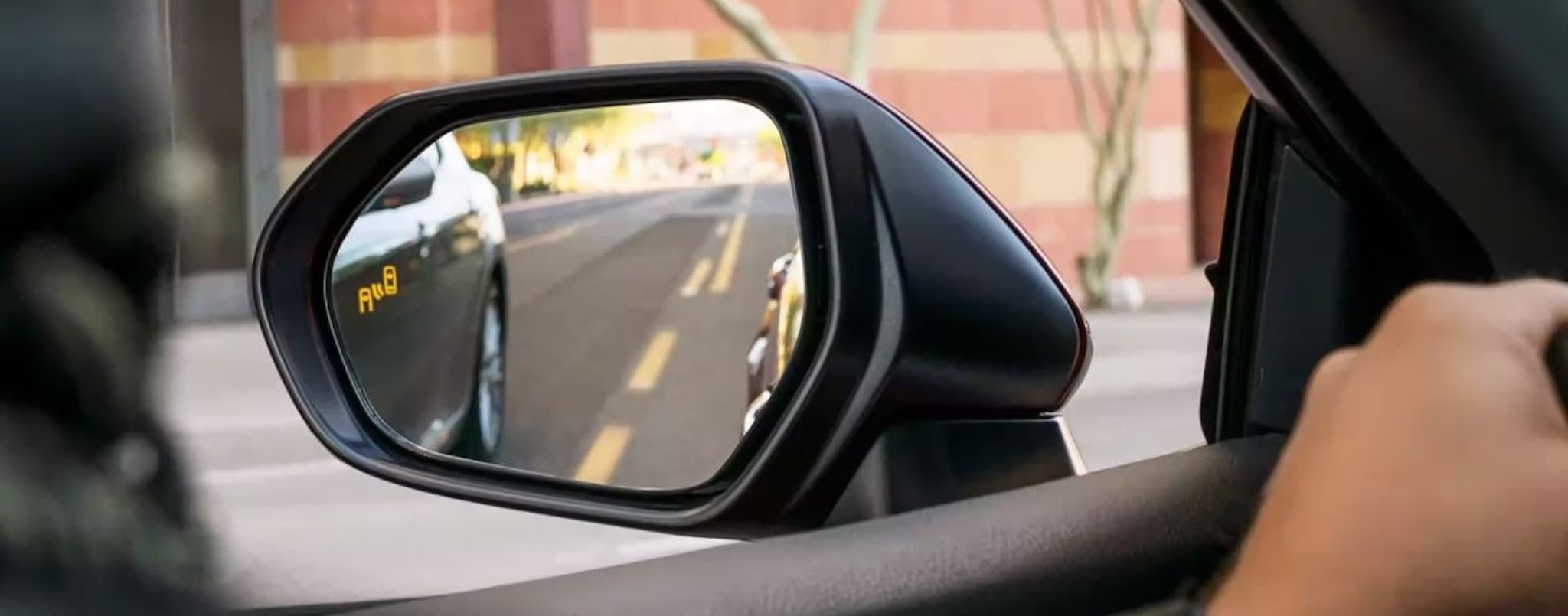 The blind sport monitoring icon is shown on the mirror of a 2024 Toyota Camry.