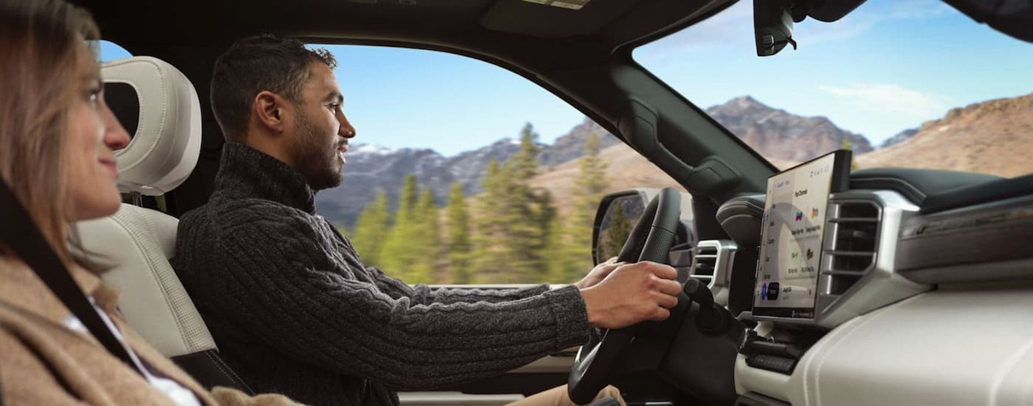 Two people are shown driving in a 2024 Toyota Sequoia Capstone.