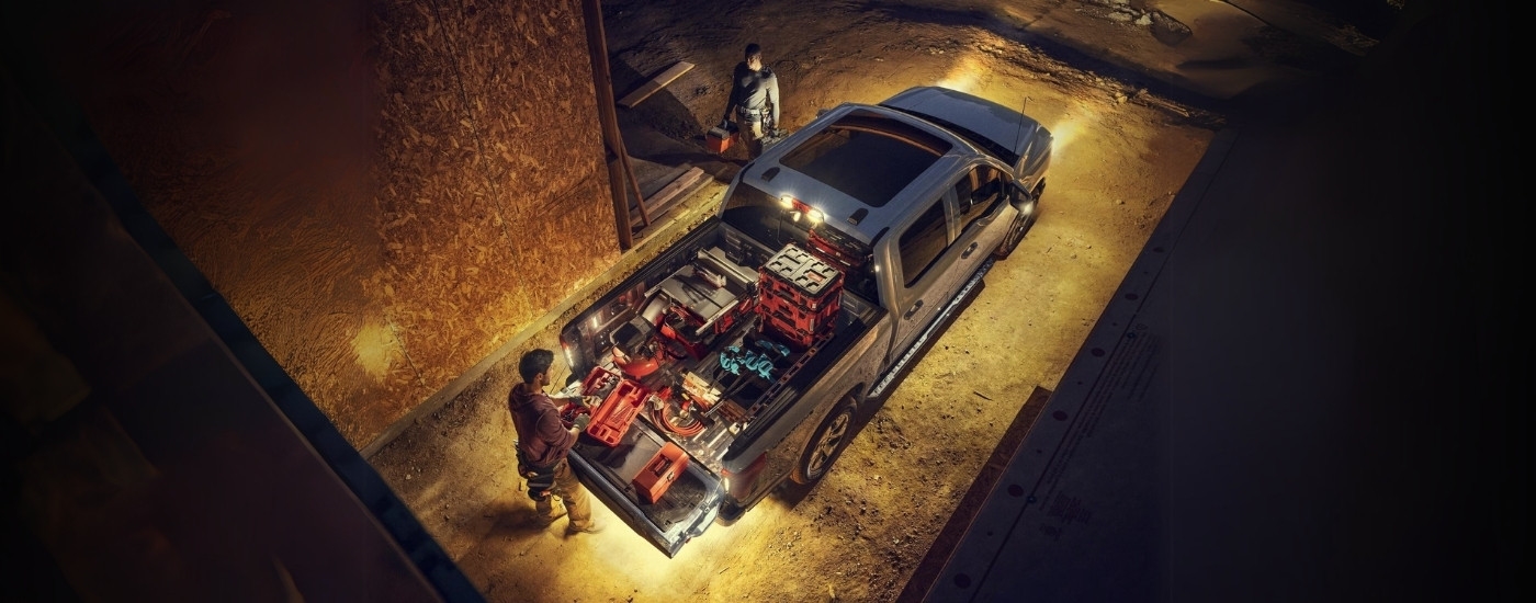 A grey 2024 Ford F-150 Lightning is shown on construction site.