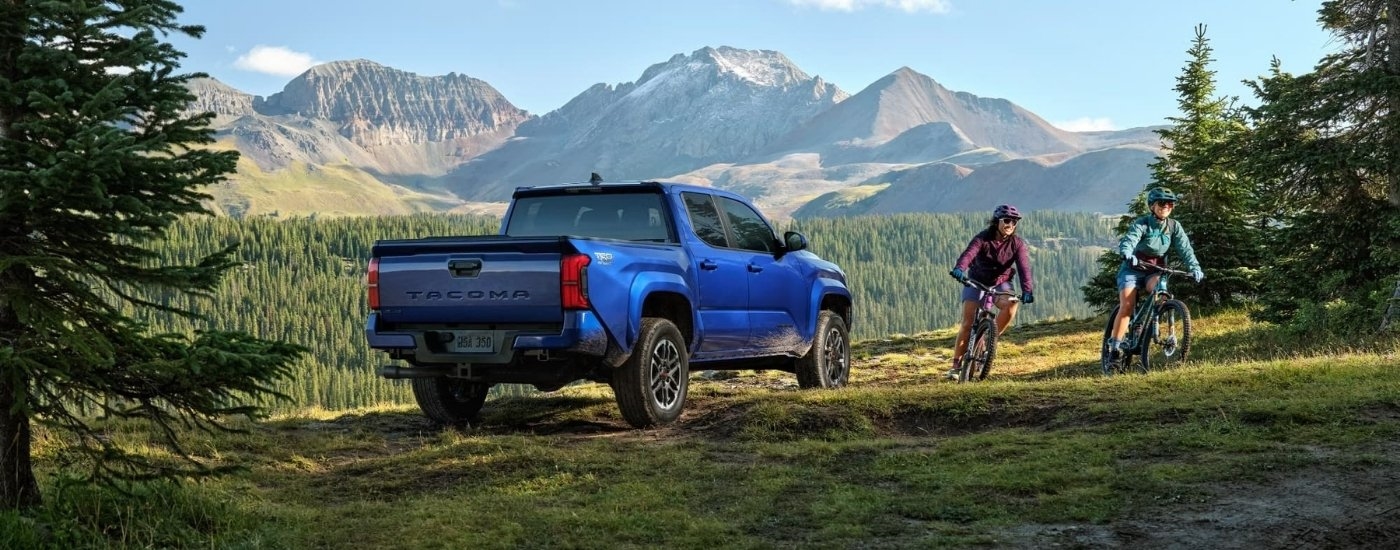 People biking are shown near a 2024 Toyota Tacoma TRD Sport.