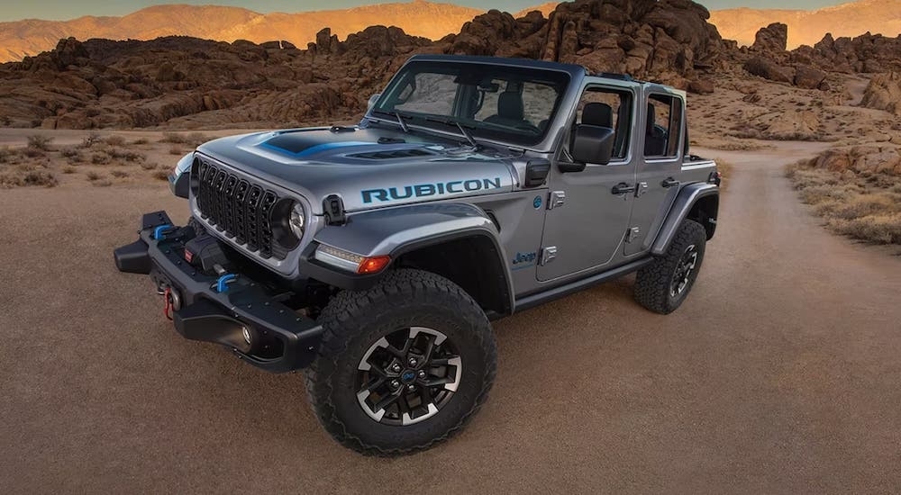 A grey 2024 Jeep Wrangler Rubicon parked off-road angled left.