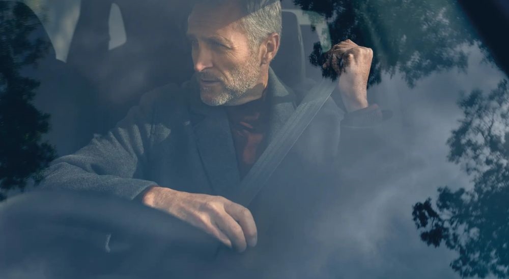 A person is shown fastening thier seatbelt in a 2025 Honda CR-V.