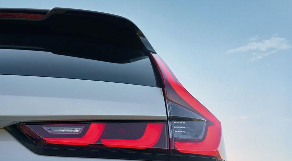 A close-up shows the passenger side taillight on a silver 2025 Honda CR-V Hybrid.