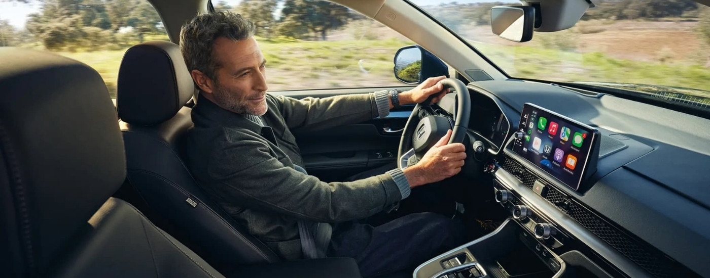 A person is shown steering a 2025 Honda CR-V.