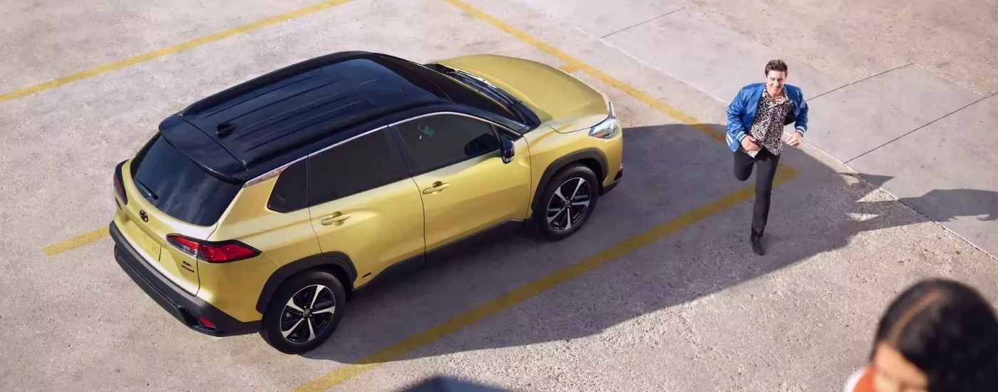 A yellow 2023 Toyota Corolla Cross Hybrid XSE is shown from a high angle.