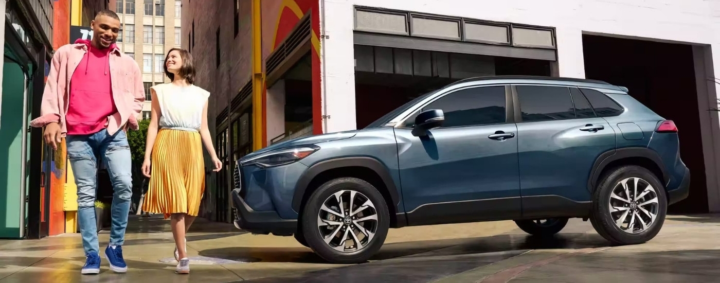 A grey 2023 Toyota Corolla Cross XLE is shown near a garage.