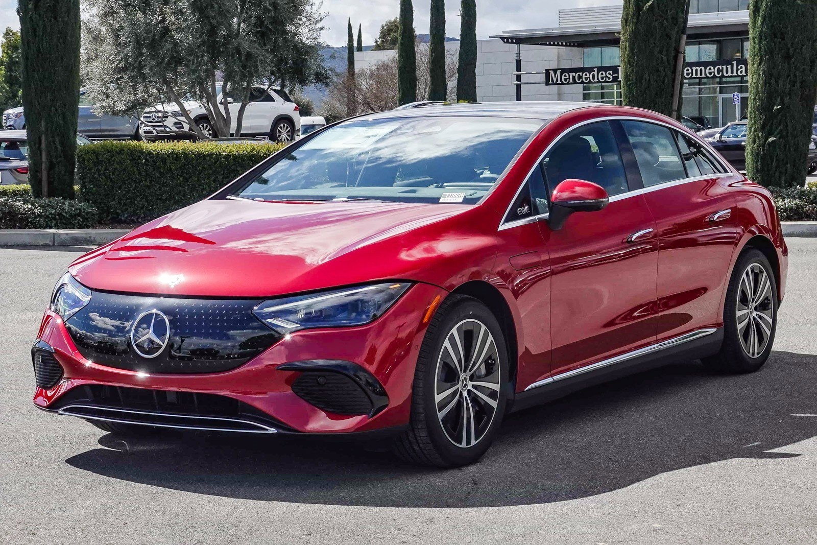 red 2025 Mercedes EQS electric sedan parked at the Mercedes-Benz of Temecula dealership in Temecula, CA