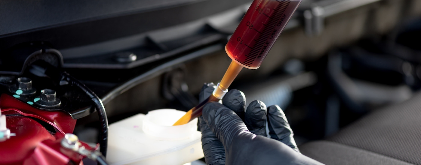 A mechanic replacing brake fluid at a service center.