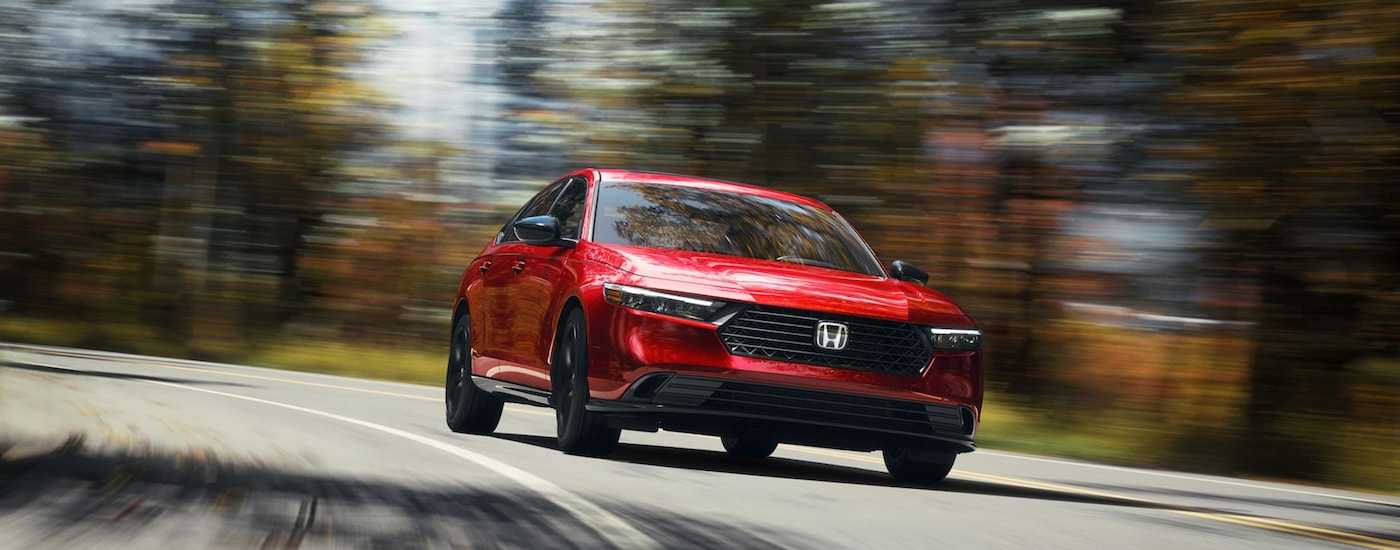 Head-on view of a red 2024 Honda Accord Sport-L Hybrid driving to a Honda dealer near Nanuet.