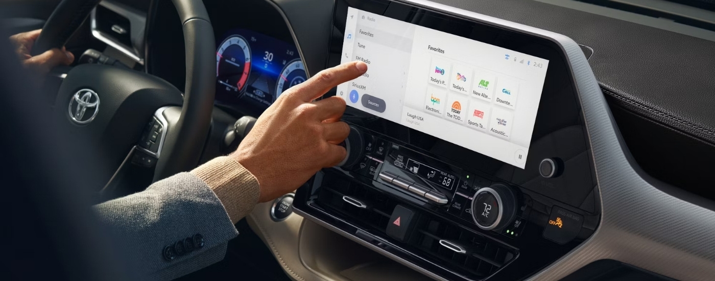 A person is shown using the infotainment screen in a 2024 Toyota Highlander Platinum.