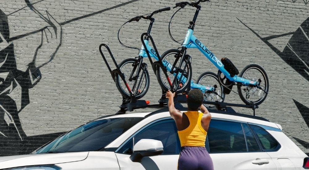 Roof racks are shown on a white 2024 Toyota Corolla Cross.