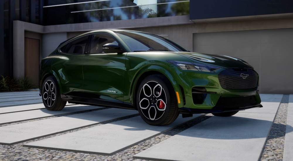 A green 2024 Ford Mustang Mach-E GT parked in front of a modern home.