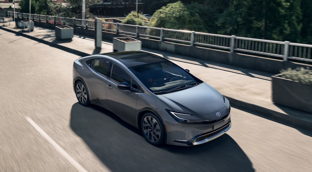 Overhead view of a silver 2025 Toyota Prius XSE Premium PHEV driving through the city.