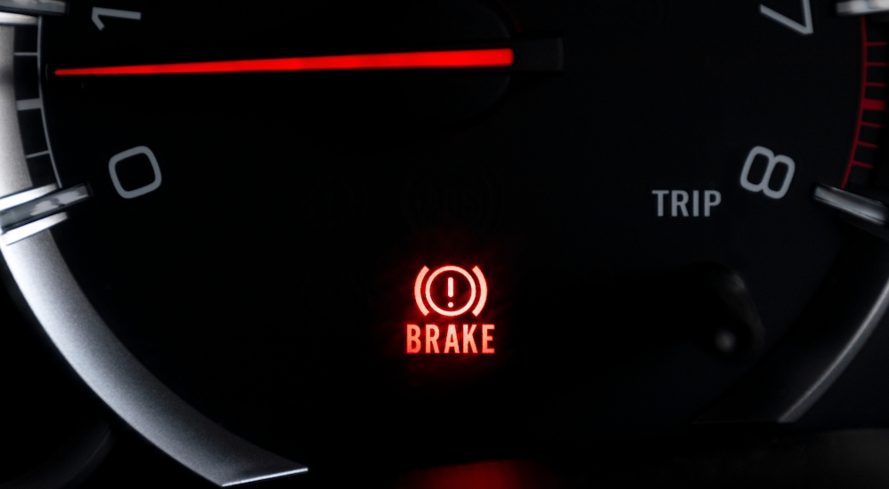 Close-up of the illuminated brake light on an instrument cluster.