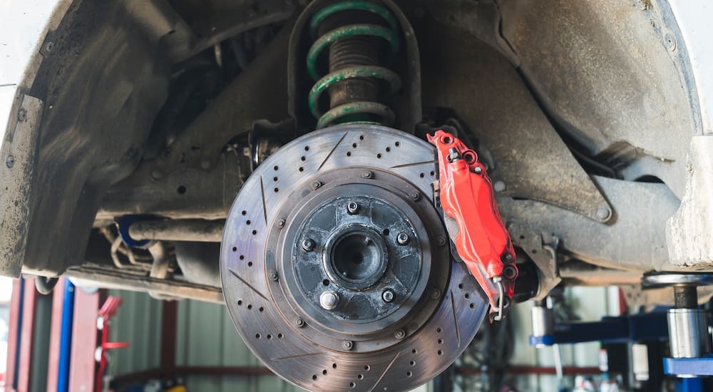 Close-up of the brakes on a vehicle on a lift.