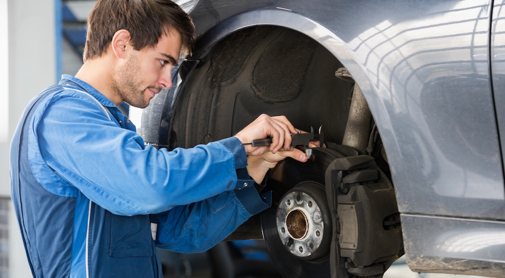 A mechanic inspecting a car's brakes during brake service.