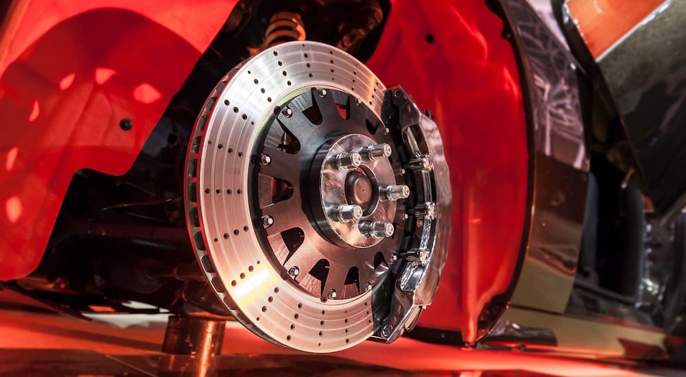 Vented and drilled brake rotors on a red vehicle.