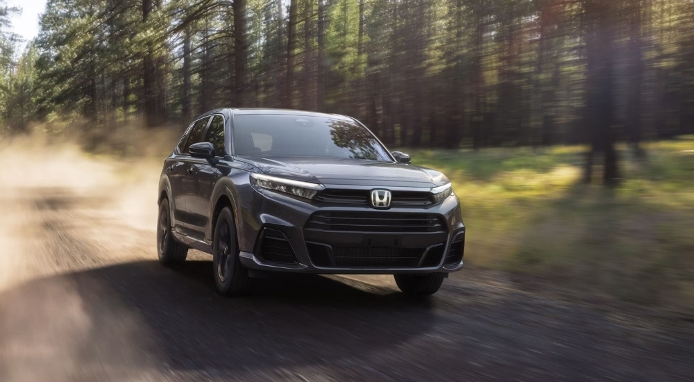 A grey 2025 Honda CR-V eFCEV is shown driving to a Honda dealer near Cottage Lake.