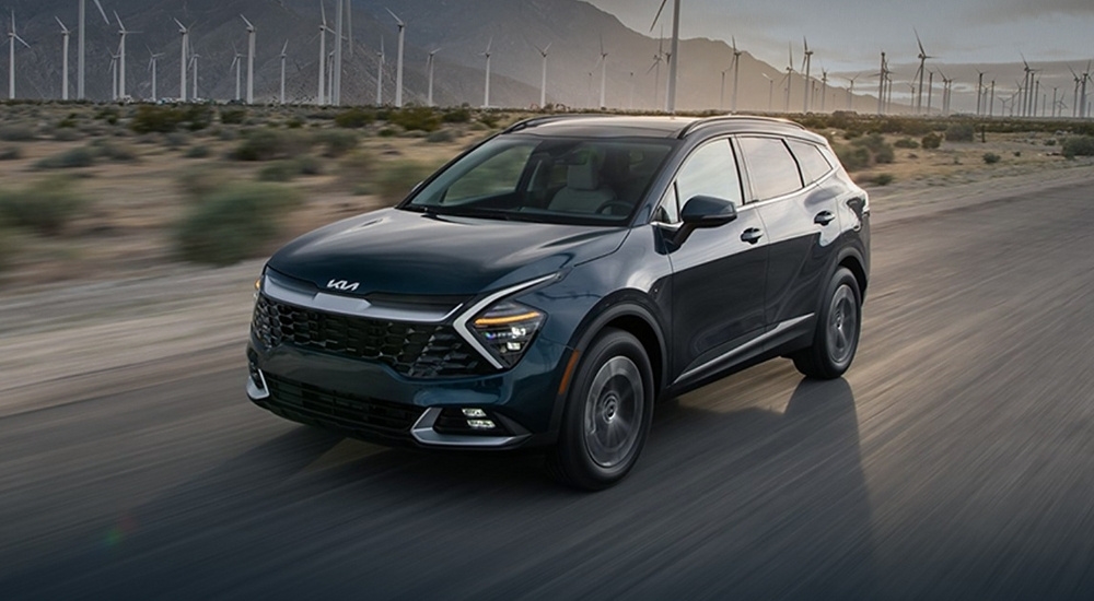 A black 2025 Kia Sportage HEV is shown driving to a Kia dealer near Seguin.