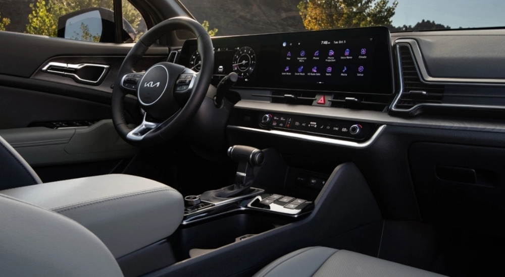 The black and grey interior and infotainment screen are shown in a 2025 Kia Sportage X-Pro Prestige.