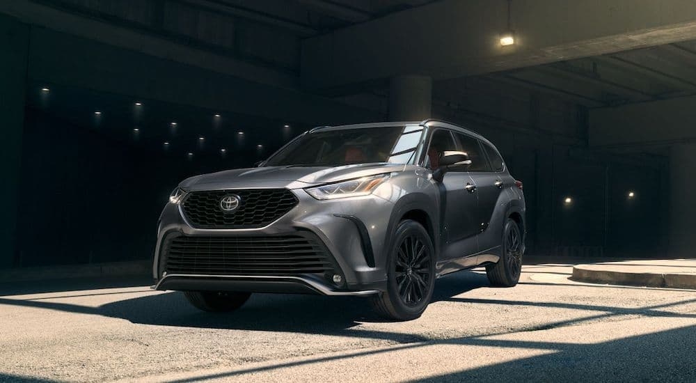 A grey 2024 Toyota Highlander parked in a parking garage and angled left.