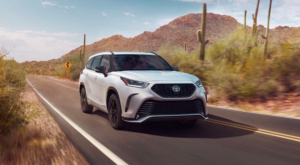 A white 2024 Toyota Highlander XSE driving in a desert.