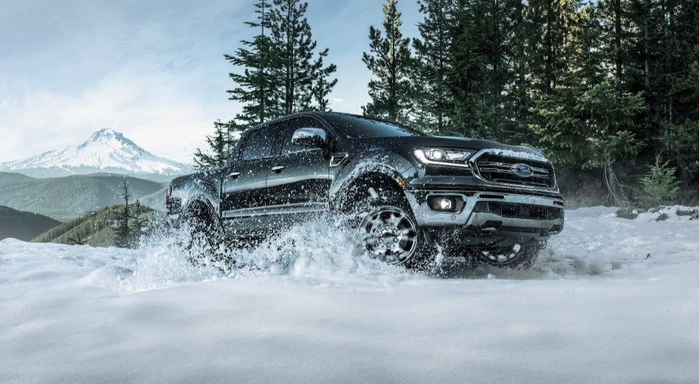 A black 2019 Ford Ranger Lariat is shown driving through snow.