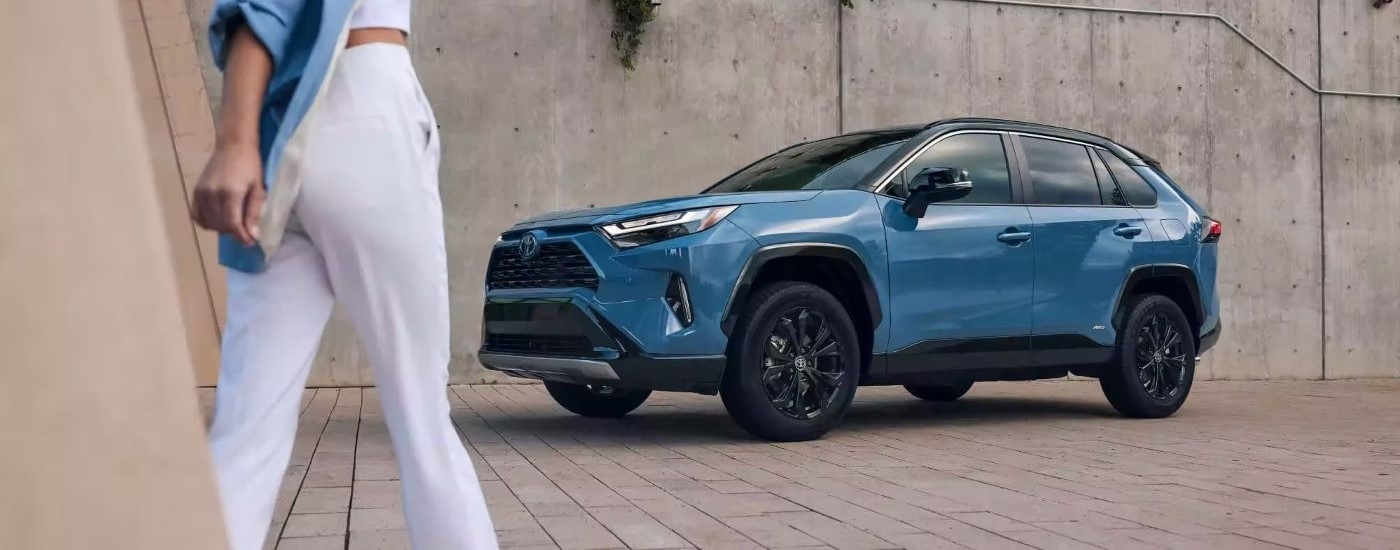 A blue 2024 Toyota RAV4 parked by a Toyota dealer near White River Junction.