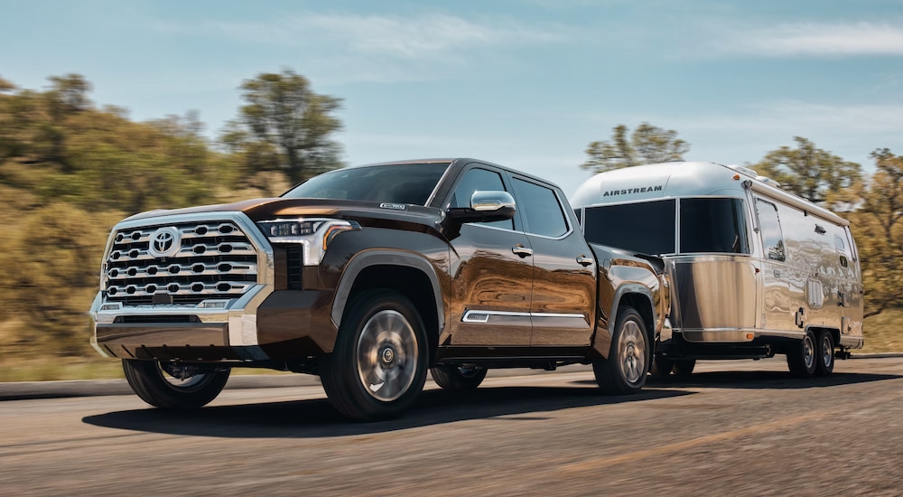 A brown 2025 Toyota Tundra 1974 Edition Hybrid towing an Airstream trailer.