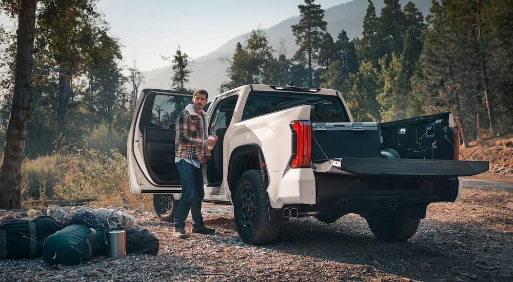 Rear view of a white 2025 Toyota Tundra TRD Pro at a campsite in the woods.