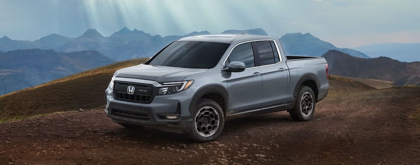 A grey 2024 Honda Ridgeline is shown from the side after leaving a Honda dealer near Warwick.