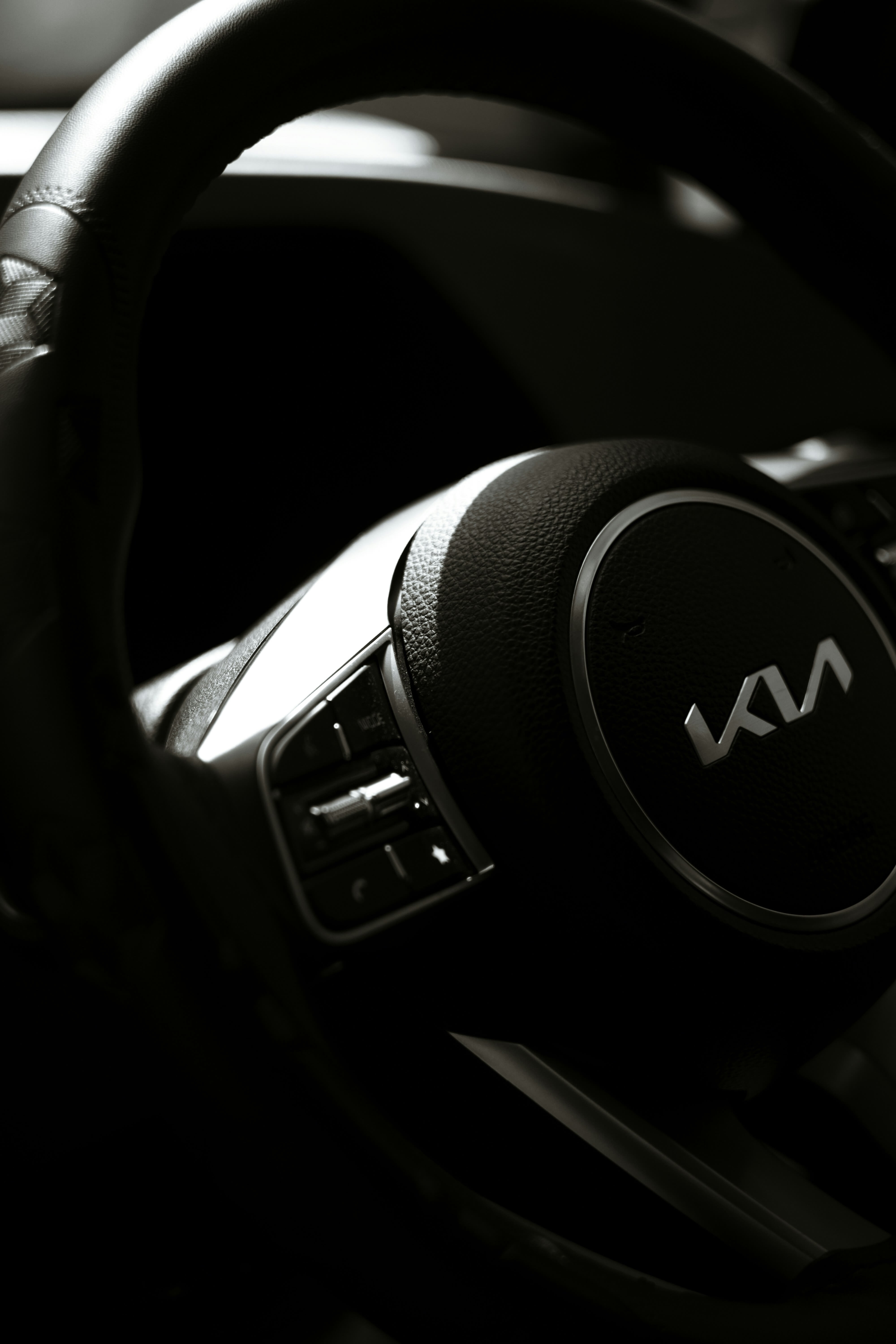 A closeup of a Kia-branded steering wheel.